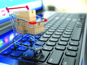 E-commerce. Shopping cart with cardboard boxes on laptop. 3d